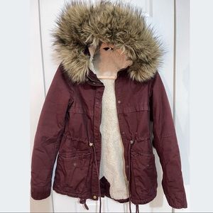 Short parka in woven cotton fabric with a hood with
detachable faux fur trim.